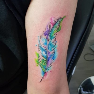 Tatouage plume style taches de couleurs turquoises vertes et lilas